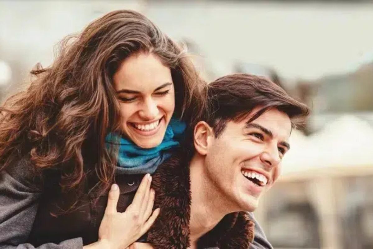 Happy couple smiling outdoors, showcasing healthy teeth and genuine happiness from quality dental care.