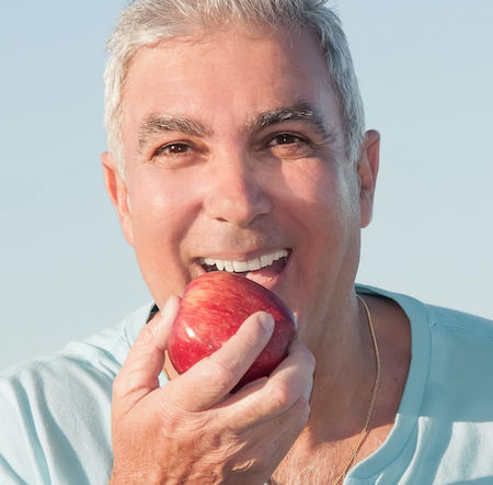 Older adult eating apple